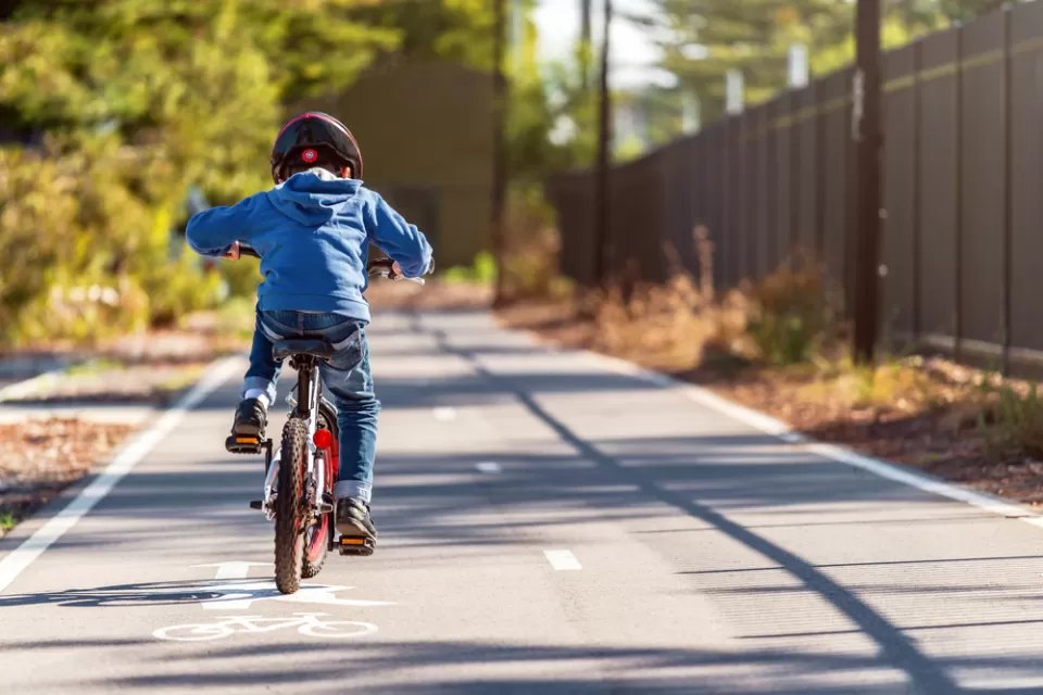 Small boy riding bike on two-way paved bike trail